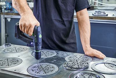 Meşterul prelucrează plăcile de material abraziv din metal