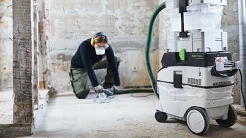 Un meșteșugar șlefuiește un podea și folosește sistemul de șlefuire a pardoselilor Festool cu extragere a prafului.